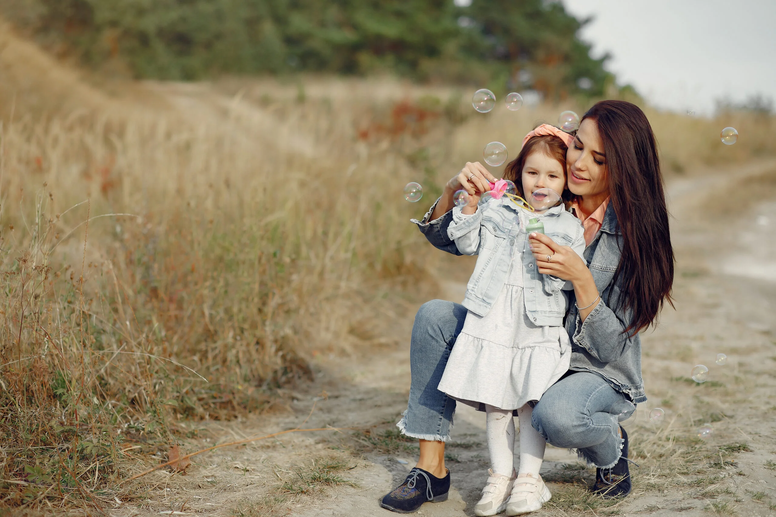 mother with little daughter playing in a autumn field